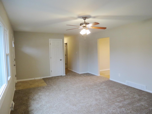 spare room with ceiling fan and light colored carpet