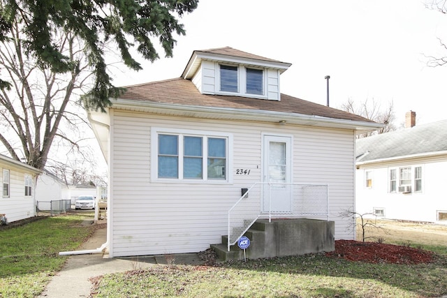 rear view of property with a lawn and cooling unit