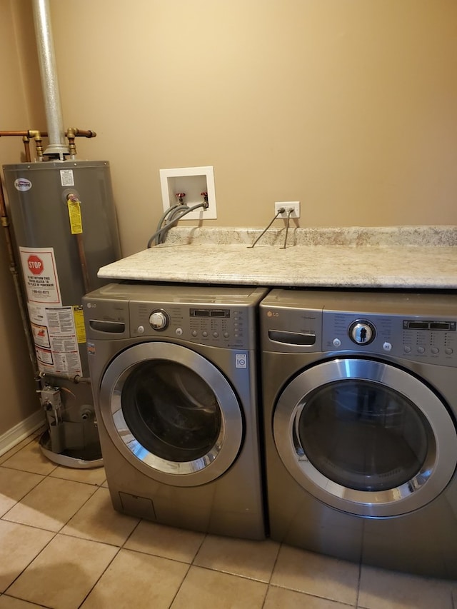 laundry area featuring light tile patterned flooring, independent washer and dryer, and water heater