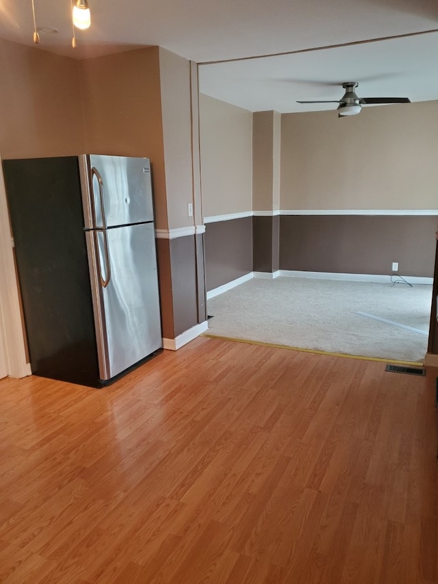 kitchen with stainless steel fridge, ceiling fan, and wood-type flooring