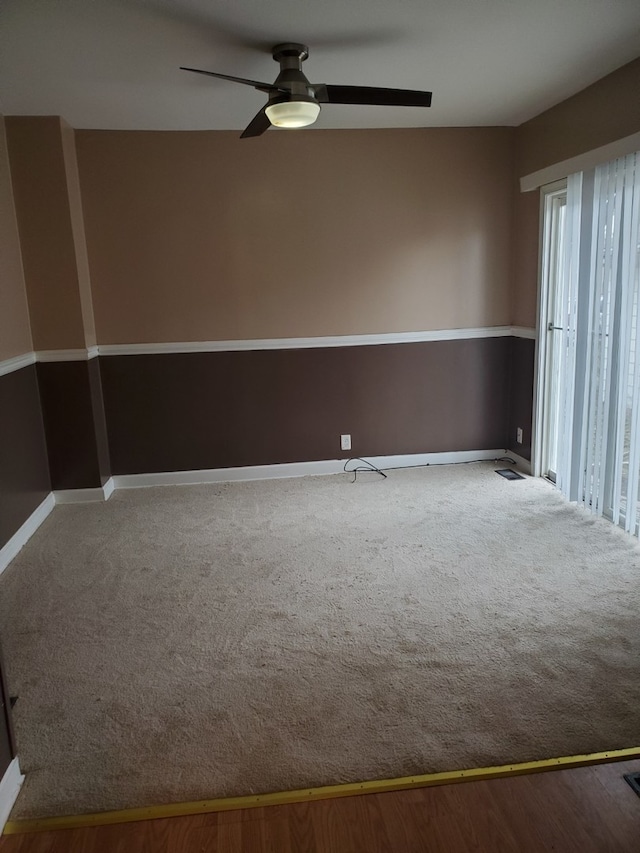 carpeted spare room featuring ceiling fan