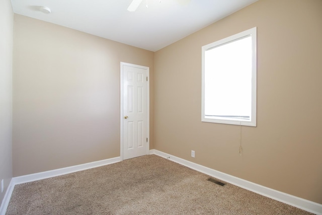 carpeted spare room featuring ceiling fan