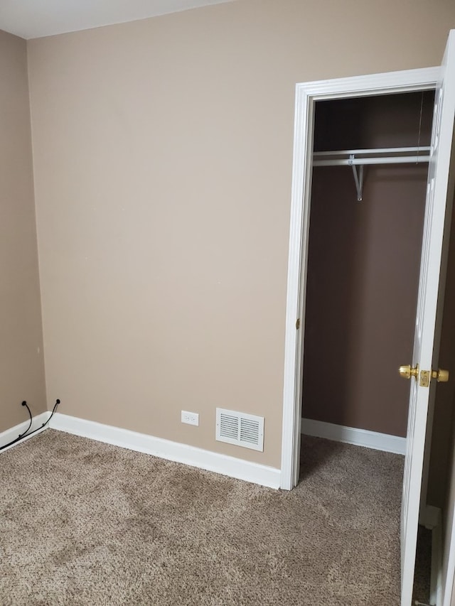 unfurnished bedroom with carpet flooring and a closet