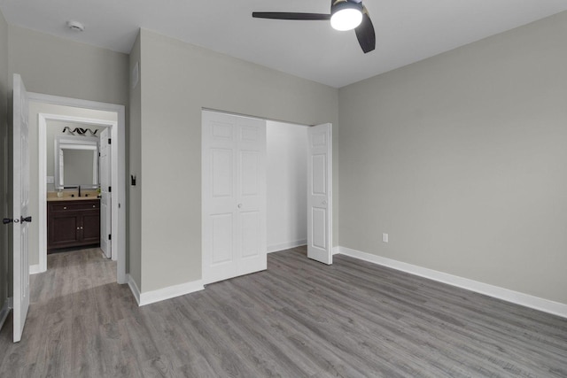 unfurnished bedroom with ceiling fan, a closet, light hardwood / wood-style floors, and sink