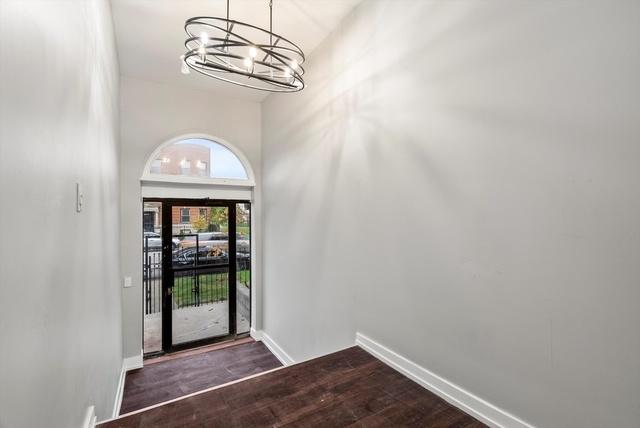 foyer featuring dark hardwood / wood-style flooring, a chandelier, and a high ceiling