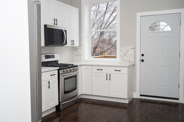 kitchen featuring stainless steel appliances, white cabinetry, and plenty of natural light