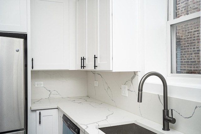 kitchen with decorative backsplash, white cabinetry, and appliances with stainless steel finishes