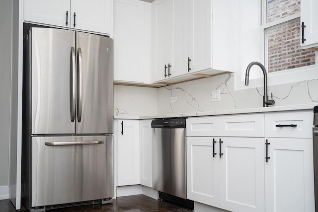 kitchen featuring backsplash, white cabinetry, sink, and stainless steel appliances