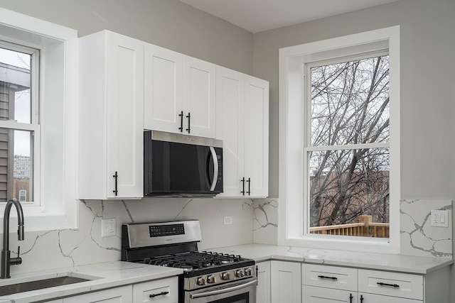 kitchen featuring white cabinets, stainless steel appliances, and sink