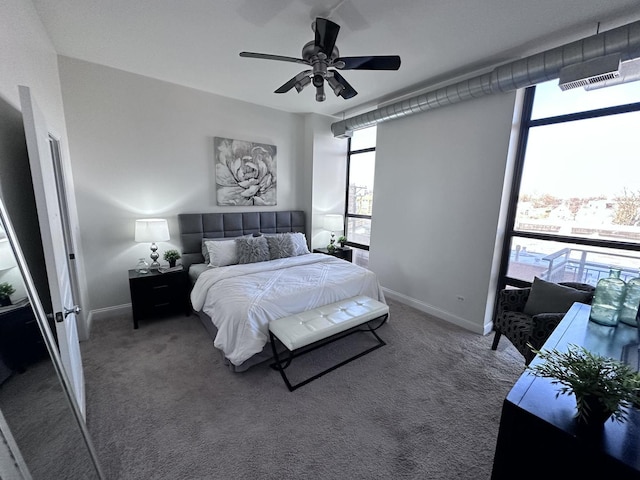 bedroom with dark carpet, ceiling fan, and multiple windows