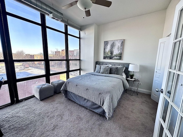 bedroom with ceiling fan, a wall of windows, and carpet floors