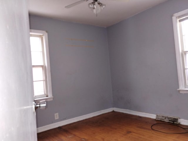 spare room with wood-type flooring, plenty of natural light, and ceiling fan