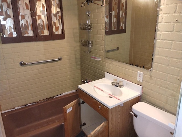 bathroom featuring vanity, brick wall, and toilet