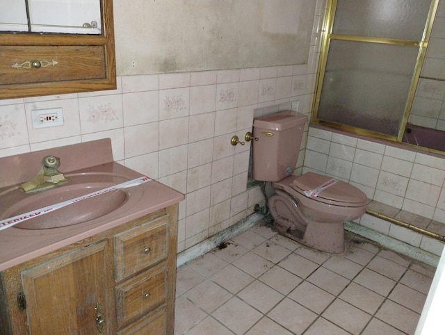 full bathroom featuring shower / bath combination with glass door, tile patterned floors, vanity, and toilet