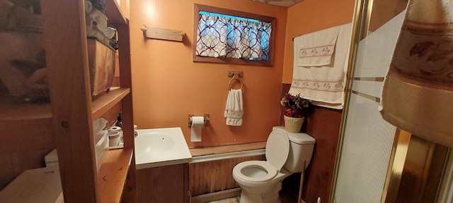 bathroom featuring vanity, toilet, and a shower with shower door