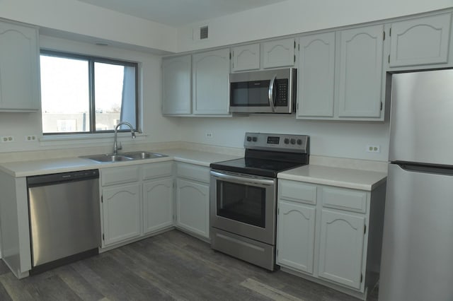 kitchen with white cabinetry, sink, dark hardwood / wood-style floors, and appliances with stainless steel finishes