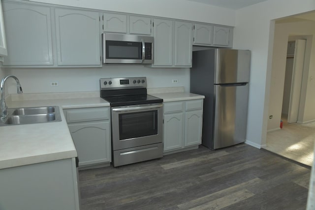 kitchen featuring appliances with stainless steel finishes, dark hardwood / wood-style flooring, and sink