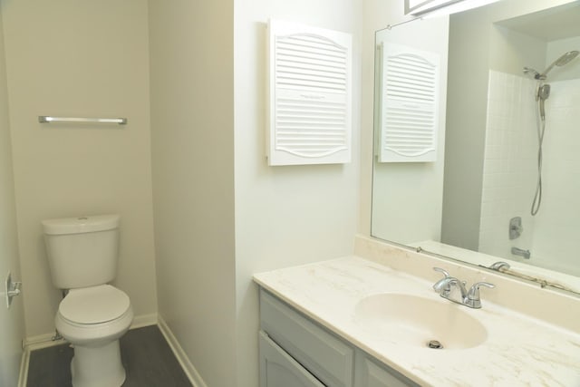 bathroom featuring a shower, vanity, and toilet