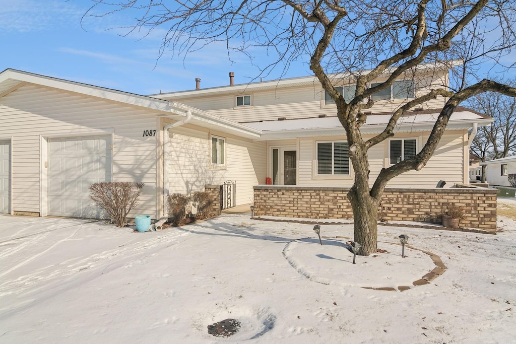 snow covered property featuring a garage