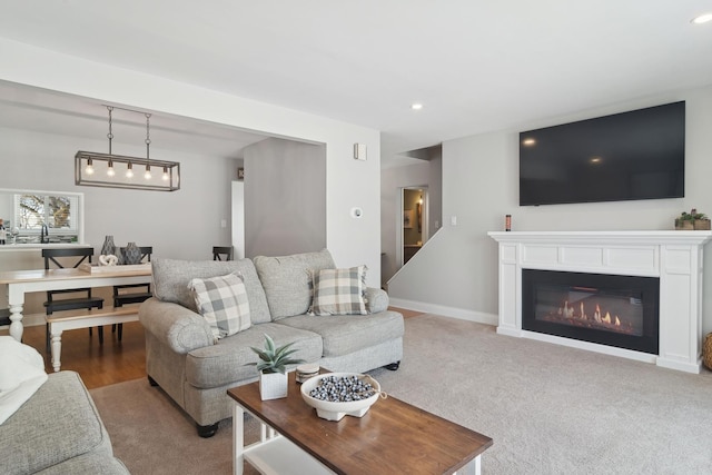 living room with light colored carpet and sink