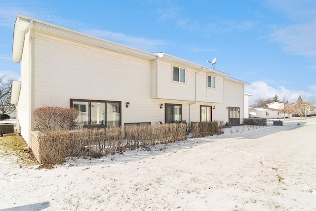 snow covered rear of property with cooling unit