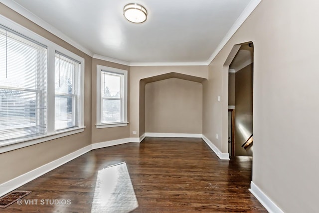 spare room featuring dark wood-type flooring and crown molding