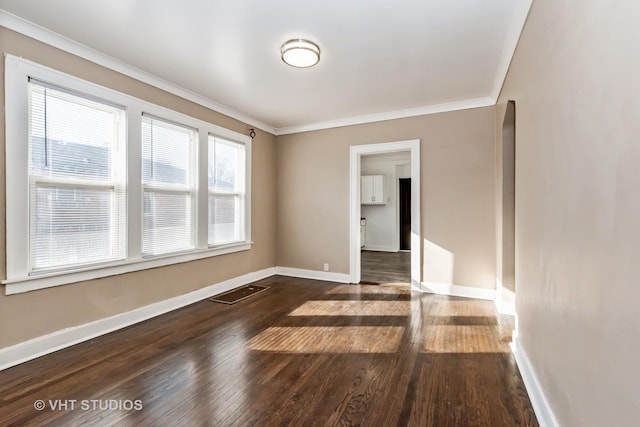 spare room with ornamental molding and dark wood-type flooring