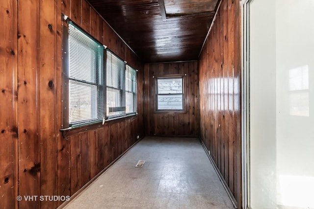 empty room featuring wood walls and wood ceiling