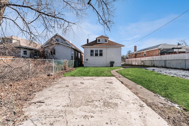 rear view of house with a lawn and a patio