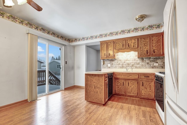 kitchen featuring white appliances, kitchen peninsula, light hardwood / wood-style floors, backsplash, and ceiling fan