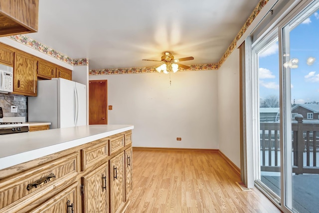 kitchen featuring white appliances, ceiling fan, tasteful backsplash, and light wood-type flooring