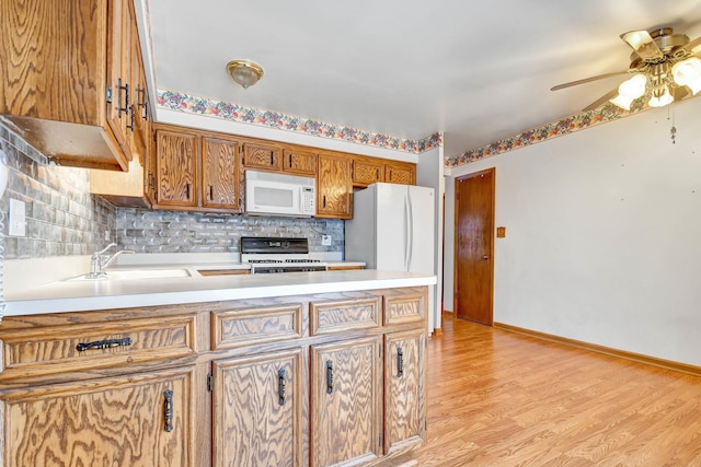 kitchen with sink, white appliances, ceiling fan, and backsplash