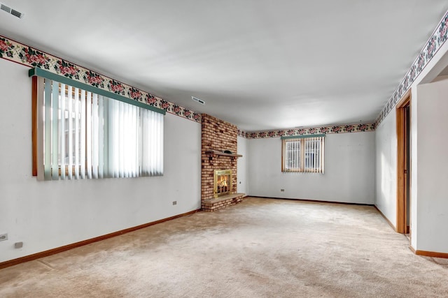 unfurnished living room with a brick fireplace and carpet flooring