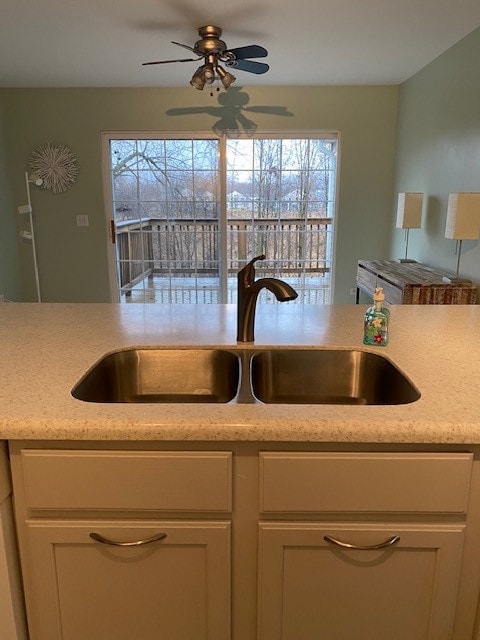 kitchen featuring white cabinetry, ceiling fan, and sink