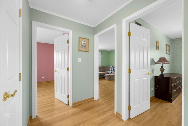 corridor with crown molding and light wood-type flooring