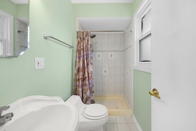 bathroom with toilet, tile patterned floors, walk in shower, and sink