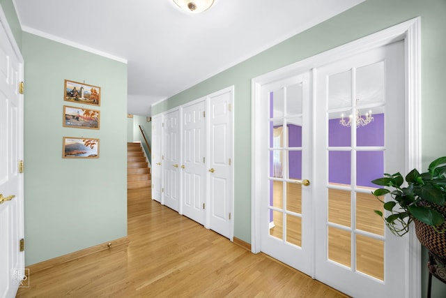 hall with light wood-type flooring and a notable chandelier