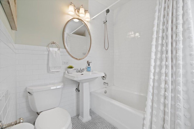 full bathroom with sink, tile patterned flooring, toilet, shower / bath combo with shower curtain, and tile walls