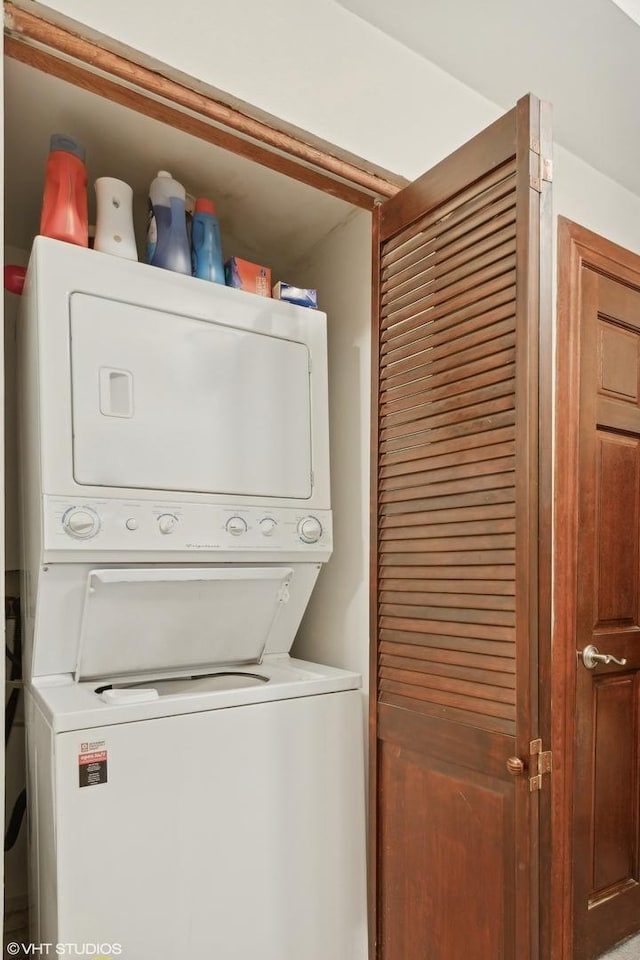 washroom featuring stacked washer / dryer