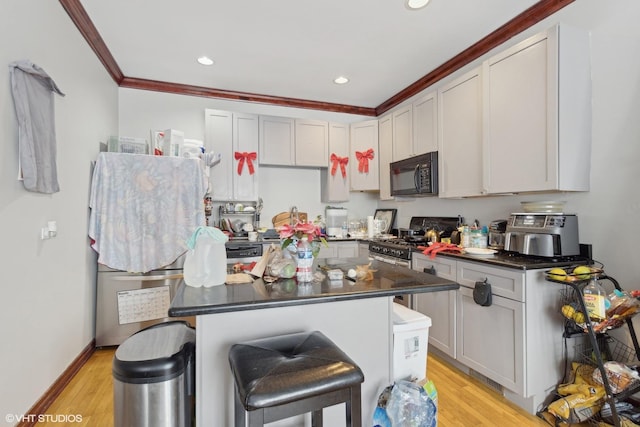 kitchen featuring a breakfast bar, a center island, light hardwood / wood-style floors, and high end stainless steel range oven