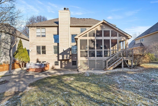 rear view of house with a sunroom, a yard, and a patio