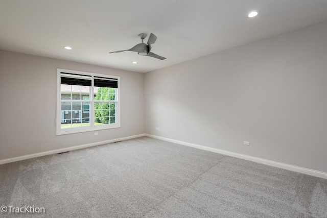 carpeted spare room featuring ceiling fan