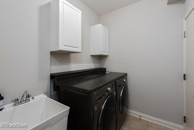 clothes washing area with light tile patterned flooring, cabinets, sink, and washing machine and dryer