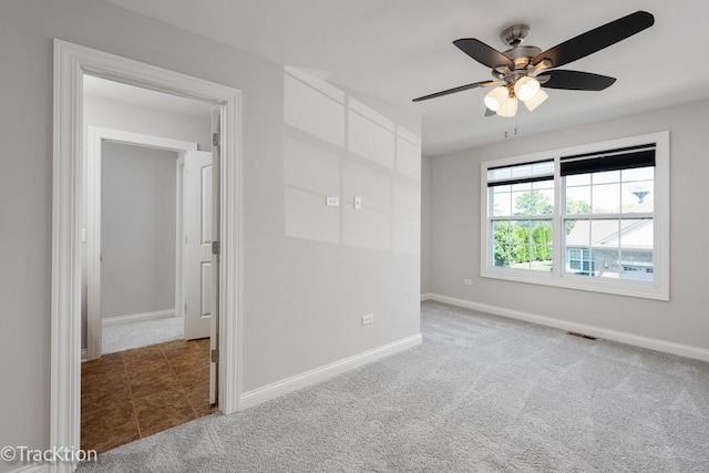 spare room featuring ceiling fan and carpet floors