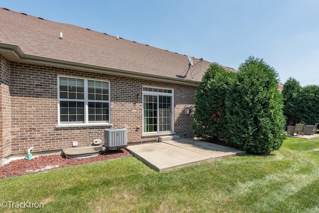 rear view of property featuring a yard, a patio, and central AC unit