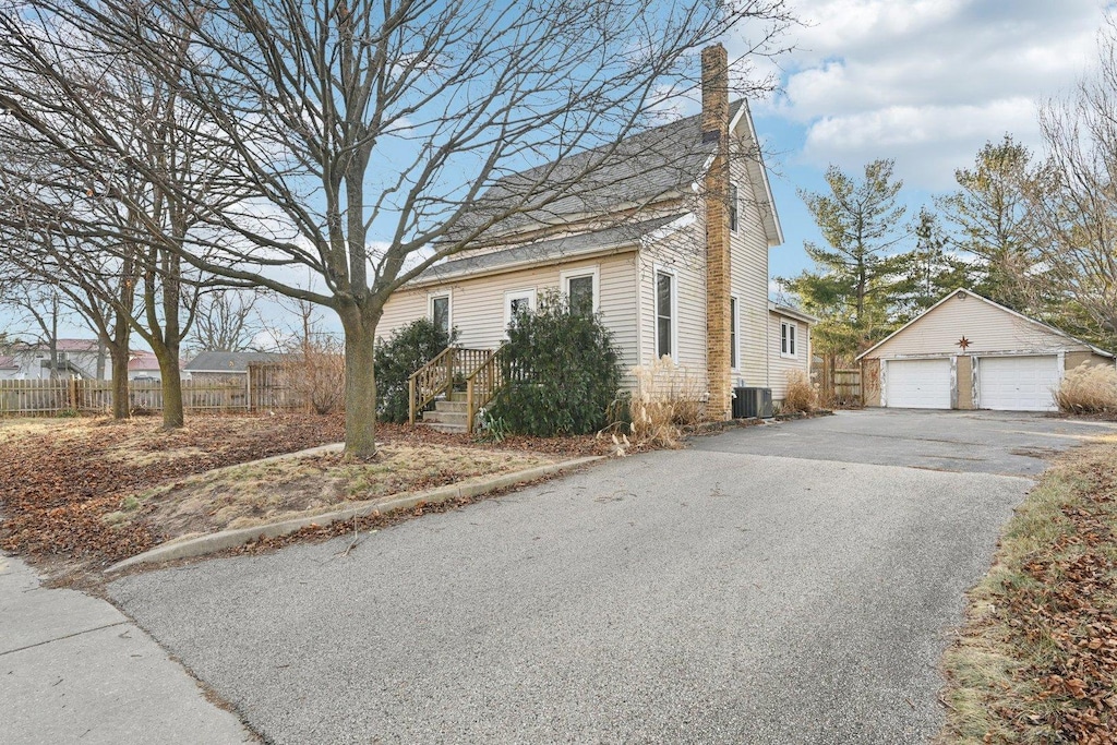 view of front of home featuring central AC, a garage, and an outdoor structure