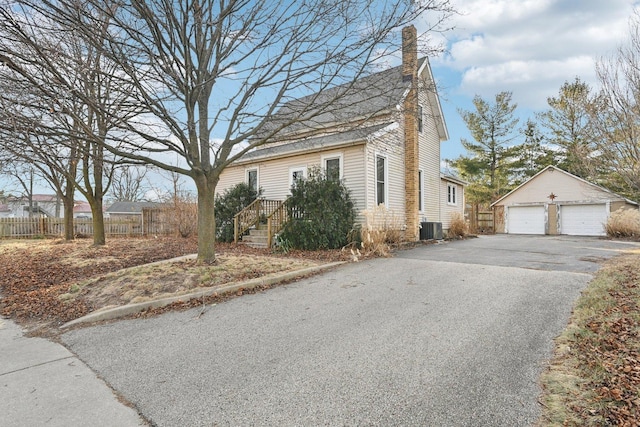 view of front of home featuring central AC, a garage, and an outdoor structure