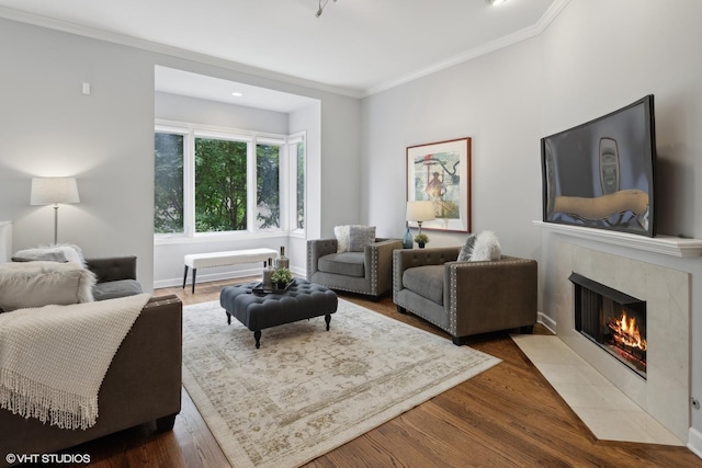 living room with dark wood-type flooring, a tile fireplace, and crown molding