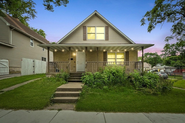 view of front of house with a porch and a yard