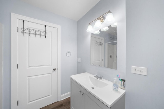 bathroom featuring hardwood / wood-style floors, vanity, and a shower